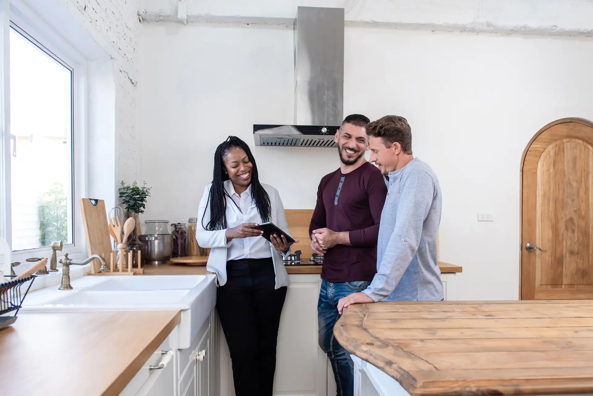 03-persona1-agent reviewing tablet with clients in modern kitchen